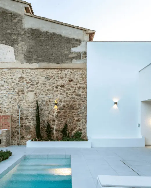 patio con piscina y muro con piedra vista